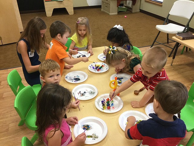 Group of children painting and working on their social skills.